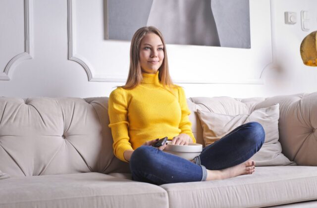 Woman relaxing on a sofa watching TV