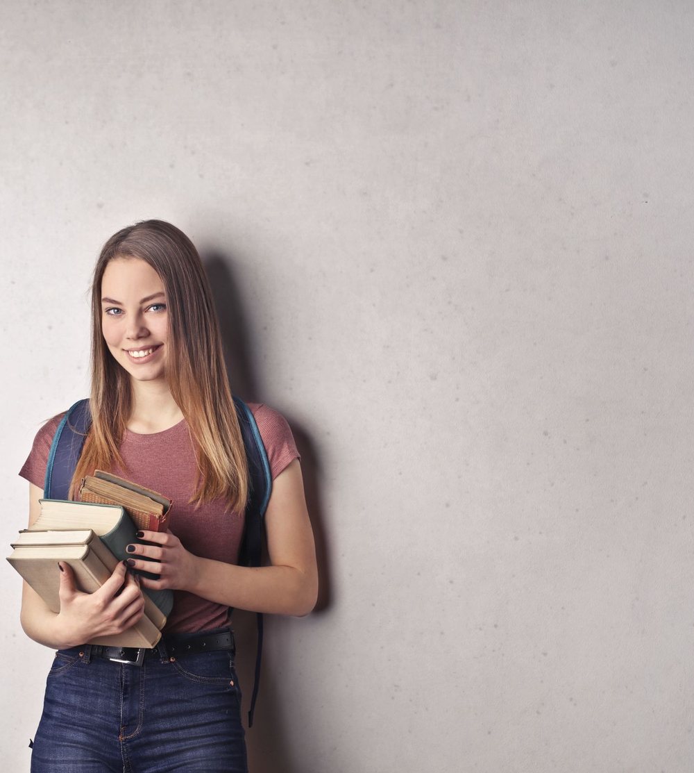 Young woman smiling while holding books